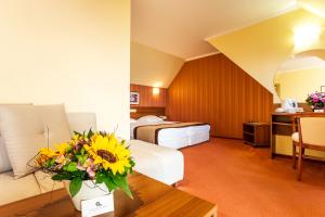 帕莫瑞Saint George Hotel & Medical Spa的配有一张床和花瓶的酒店客房