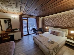 旧扎戈拉Семеен Хотел Берое的一间带一张床和一张书桌的卧室以及一个阳台