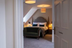福伊Fowey Hall Hotel的一间卧室配有一张床和一把绿色椅子