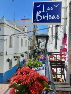 EsteponaLas Brisas Estepona的一座带鲜花和标志的建筑阳台