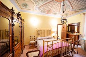 SassoferratoDegli Alessandri Palace的一间卧室设有一张床、椅子和天花板