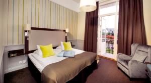 奥斯卡港克拉利奥波斯特连锁酒店的卧室配有床、椅子和窗户。