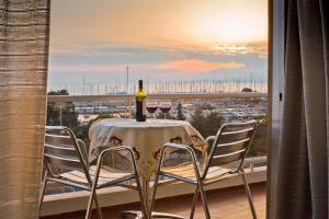 雅典玛里娜阿利莫斯公寓酒店的阳台上的桌子和两杯葡萄酒