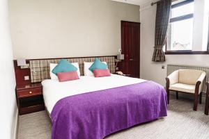 斯托诺韦卡拉德旅馆的一间卧室配有一张大床和紫色毯子