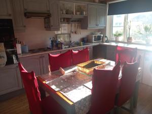 卡斯莱兰Home Comforts的厨房配有红色椅子和桌子