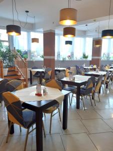 米兹多洛杰库拉布旅馆的餐厅设有桌椅和窗户。