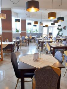 米兹多洛杰库拉布旅馆的用餐室配有桌椅和灯光