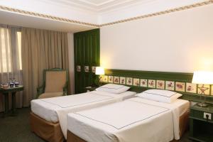 伊兹密尔伊兹密尔安莫酒店的绿墙旅馆客房的两张床