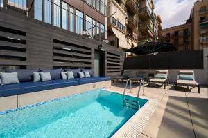 巴塞罗那巴塞罗那加泰罗尼亚格兰维亚大道酒店的一座建筑物中央的游泳池