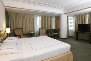 伊兹密尔伊兹密尔安莫酒店的酒店客房设有一张大床和一台电视。