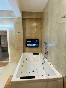 海得拉巴White House Sky View Theatre Villa in Gachibowli的浴室设有带电视的大浴缸。