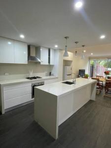 悉尼Ideal 3 Bedroom House City Centre Glebe 2 E-Bikes Included的一间厨房,配有白色橱柜和厨房岛
