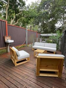悉尼Ideal 3 Bedroom House City Centre Glebe 2 E-Bikes Included的木制甲板上配有沙发和椅子的庭院
