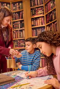 谢西迪士尼乐园酒店的一位女人和两个孩子在图书馆看地图