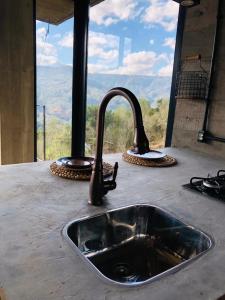 乌鲁比西Cabana Efatah - Pousada Colina dos Ventos的带水槽的厨房台面和窗户