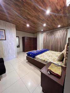 Nathia GaliBlue sky Apartment的一间卧室设有一张大床和木制天花板
