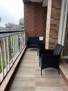 Nathia GaliBlue sky Apartment的阳台配有两把椅子和栏杆