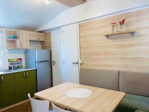 耶泽拉Mobile home Comfort Jezera Murter的一间带桌子和冰箱的小厨房