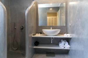 阿克罗蒂里Acroterra Rosa Luxury Suites & Spa的一间带水槽和镜子的浴室