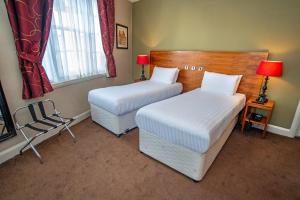 什鲁斯伯里威瑟斯本什鲁斯伯里酒店的客房设有两张床、一把椅子和窗户。