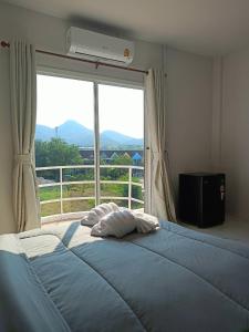 华欣Wave House Studio Huahin的一间卧室设有一张大床和大窗户