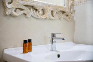拉里布奇巴索波德尔农庄酒店的浴室水槽上方有2瓶水
