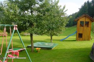 埃尔察赫Mosertonihof的一个带树、滑梯和游戏结构的游乐场