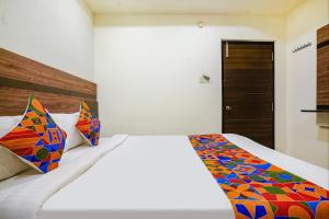维杰亚瓦达FabHotel Raj Vihar Residency的一间卧室配有一张带彩色毯子的床