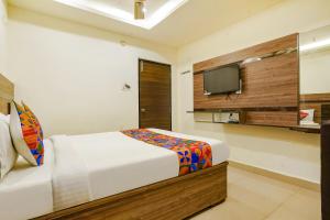 维杰亚瓦达FabHotel Raj Vihar Residency的一间卧室配有一张床和一台平面电视