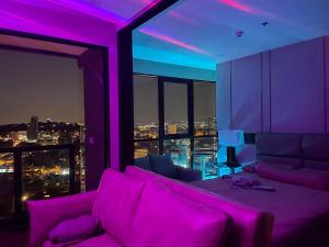 南芭堤雅THE PANORA PATTAYA的紫色的客厅配有沙发和窗户