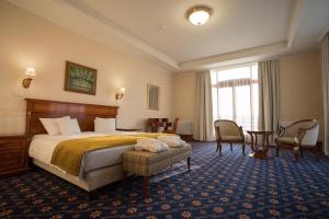 GödHotel Golden Palace的酒店客房带一张床、一张桌子和椅子