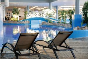 朗厄松群岛品质酒店的两把椅子坐在游泳池前