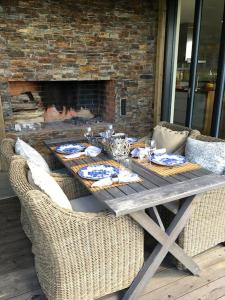 卡特琳娜霍尔姆Luxury Lakeside Villa的一张带藤椅的木桌和壁炉