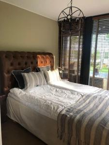 卡特琳娜霍尔姆Luxury Lakeside Villa的一间卧室配有一张大床和木制床头板