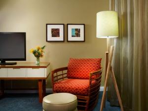 檀香山Oasis Hotel Waikiki的一间带椅子和一张书桌及电视的房间