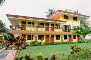 邦劳Villa Lourdes Resort的带阳台的大型黄色房屋