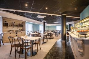 迭戈姆布鲁塞尔机场托恩酒店的一间带桌椅的餐厅和一间酒吧