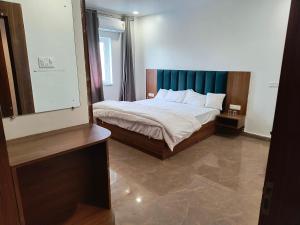 SasarāmAKS INTERNATIONAL HOTEL AND RESORT的一间卧室配有一张蓝色床头板的床