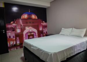 马拉巴Amazônia Palacce Hotel的卧室配有一张床,墙上涂有建筑的油漆