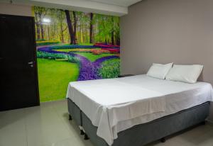 马拉巴Amazônia Palacce Hotel的一间卧室配有一张壁画床
