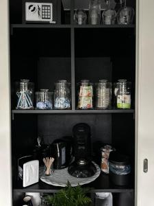 伊皮Bed en Breakfast的装满玻璃罐的食品储藏室和咖啡壶