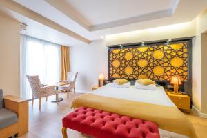 伊斯坦布尔Suite Rooms By Vvrr的一间卧室设有一张大床和一张红色长凳