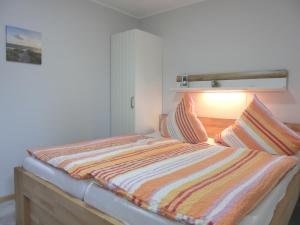 格拉尔-米里茨Ferienhaus FH9的一张带条纹棉被的床