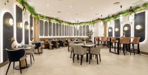 巴塞罗那Ilunion Les Corts Spa的用餐室配有桌椅和植物