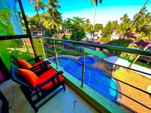卡兰古特Hotel Shivam Inn - Near Calangute Beach的阳台上的两把椅子,俯瞰着水面