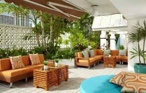 檀香山Oasis Hotel Waikiki的户外庭院配有沙发和植物