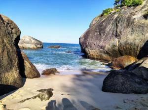 马里卡Casa na praia com ar condicionado, muito aconchegante.的拥有大岩石和海洋的海滩