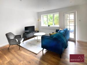 West ClandonGuildford - 2 Bedroom House的客厅配有蓝色的沙发和椅子