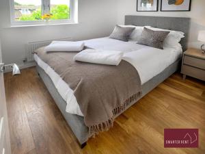 West ClandonGuildford - 2 Bedroom House的一张配有白色床单和枕头的大床