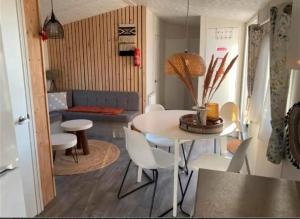 劳雷尔苏格EnJoy Meer und See Ferienhaus -Aan het Lauwersmeer in Lauwersoog -3 Slaapkamers - 1 tot 6 pers -Vanaf 14u al inchecken! Free WIFI!的客厅配有桌椅和沙发